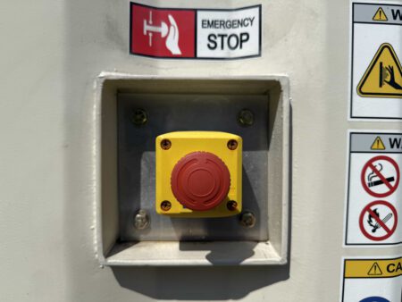 Emergency stop button mounted on generator enclosure.
