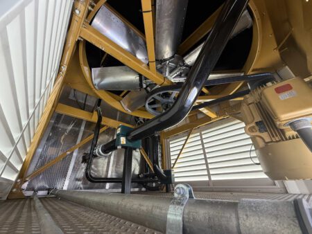 Radiator cooling fan assembly beneath Caterpillar generator housing.