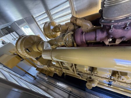 Side angled view of Caterpillar 3516 turbochargers and exhaust system.