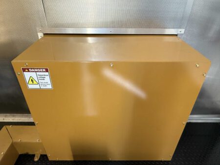 Interior view of generator enclosure with hazard label.
