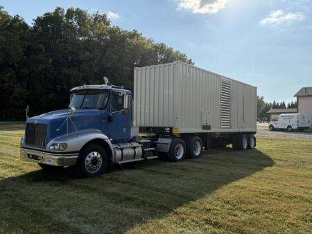 Caterpillar C27 800kW generator container on trailer, front-left view.