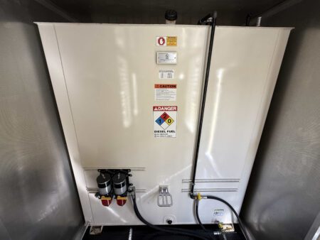 Sub-base diesel fuel day tank with warning labels and dual Racor filters.
