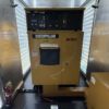 Containerized generator enclosure front view with Caterpillar control panel.