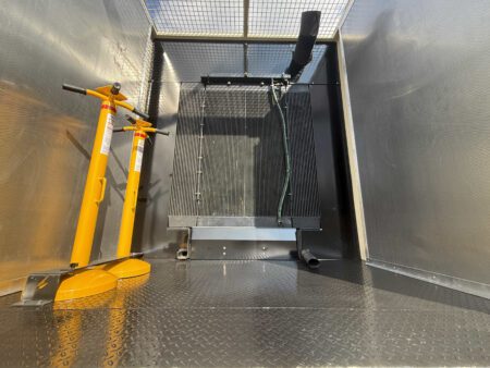 Rear enclosure view of Caterpillar generator radiator with lifting jacks stored inside.