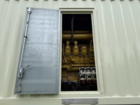 Open engine-side service access door showing Caterpillar 3516 engine.