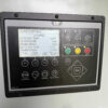 Caterpillar EMCP 4.4 digital generator control panel showing software version and operational controls.