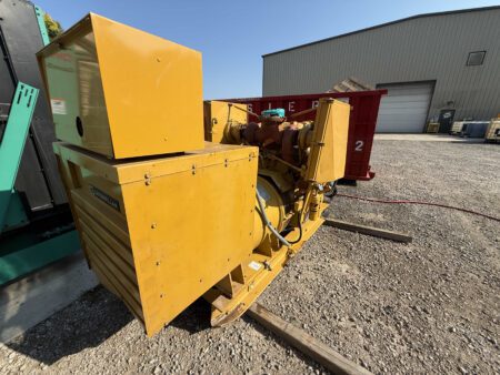 Rear side angle of 1988 Caterpillar 3412 600kW diesel generator with alternator housing and breaker cabinet