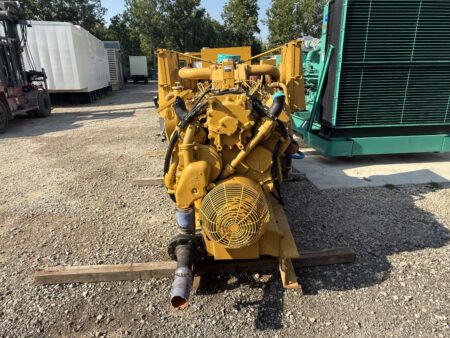 Front view of 1988 Caterpillar 3412 600kW diesel generator with protective fan guard and piping