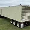 Caterpillar generator container on trailer, front-right angle.