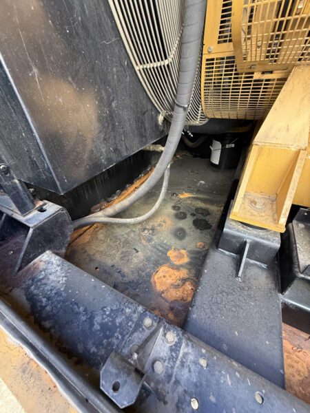 Base pan near radiator on 2000 CAT 3412 500kW generator (S/N BPG00168) showing surface rust/staining inside the enclosure.