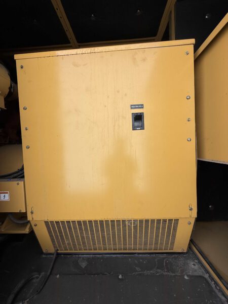Output breaker cabinet inside 2000 CAT 3412 500kW generator enclosure; handle labeled “FEED FOR ATS-A,” louvered vent at bottom.