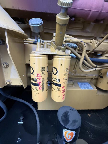 Dual CAT 1R-0749 fuel filters with hand priming pump on 2000 CAT 3412 500 kW generator (S/N BPG00168); service date marked on cans.