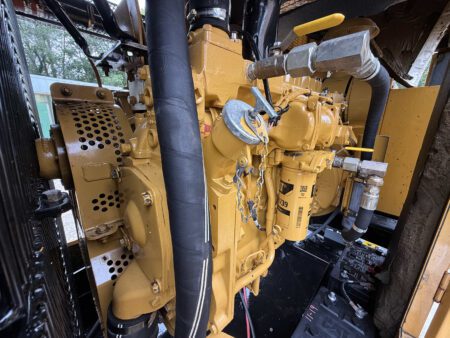 Close-up side view of a Caterpillar 3306 engine on a 2003 CAT 250kW generator, showing fuel filters, hoses, and battery connections.