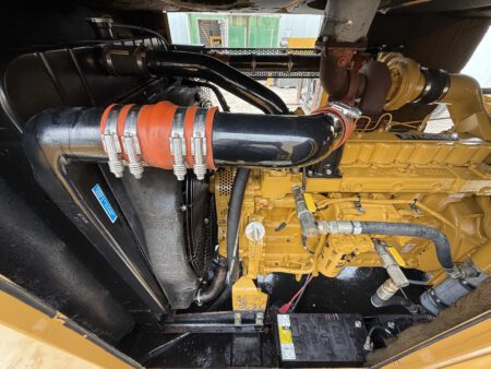 Close-up of the cooling system and radiator connections on a 2003 Caterpillar 3306 250kW generator, showing radiator, coolant hoses, and turbocharger.
