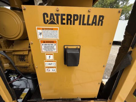 Front breaker panel on a 2003 Caterpillar 3306 250kW generator with Caterpillar branding and multiple safety warning labels.