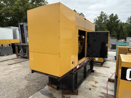 2003 Caterpillar 3306 250kW generator, front-left side view with enclosure door open, exposing part of the engine and mounted on a sub-base fuel tank.