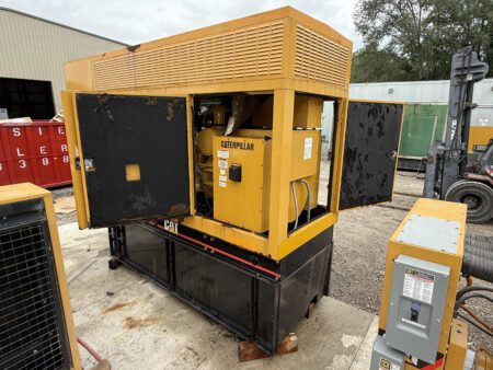 2003 Caterpillar 3306 250kW generator, front-right side view with both enclosure doors open, exposing Caterpillar engine and internal components, mounted on sub-base fuel tank outdoors.