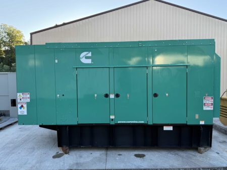 Rear view of a 2018 Cummins DFEK 500kW diesel generator set in a green sound-attenuated enclosure.