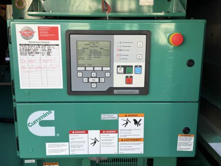 Cummins PowerCommand control panel with emergency stop button and maintenance log on a 2018 DFEK 500kW diesel generator.