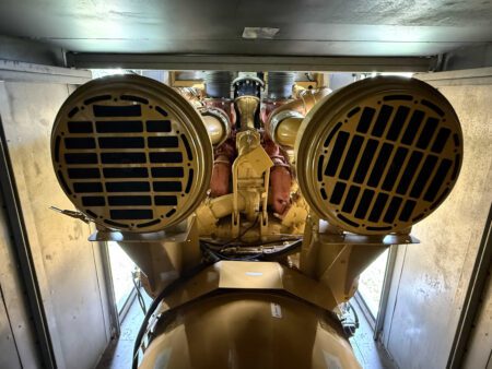 Close-up of the Caterpillar 3516C diesel generator’s turbocharger section, featuring dual turbochargers, exhaust manifolds, and insulated piping. This image highlights the heavy-duty forced induction system that boosts efficiency and power output for standby and prime applications.