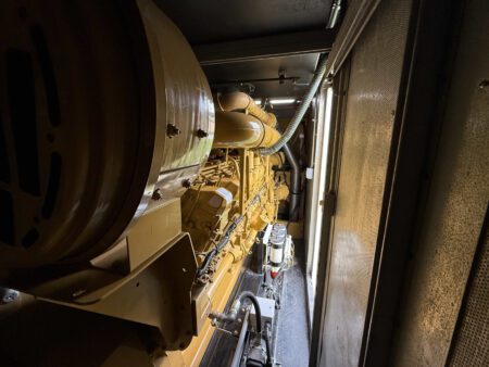 3516C diesel generator showing engine assembly with alternator and fuel filtration system inside container.