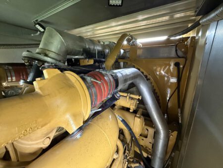 Caterpillar 3516C generator radiator and cooling system assembly with piping and fan housing.