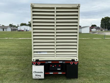 Right side view of Caterpillar generator container on trailer.