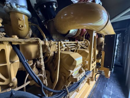 Caterpillar 3516C diesel engine intake manifold and cylinder head assembly with protective wiring harnesses.
