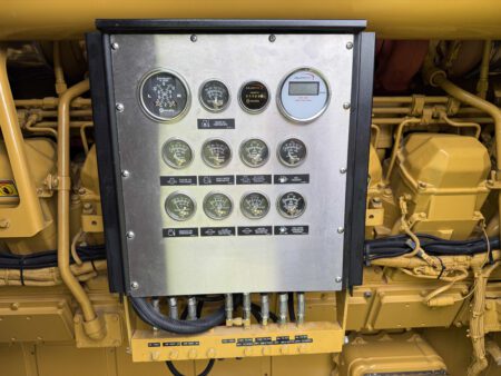 Engine-mounted gauge panel on a Caterpillar 3516C diesel generator showing multiple analog and digital gauges.