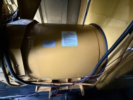 Caterpillar 3516C generator end alternator with warning and specification labels.