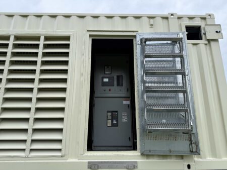 Side view of Caterpillar 3516C containerized generator enclosure showing breaker access door open with ladder steps and control panels visible inside.