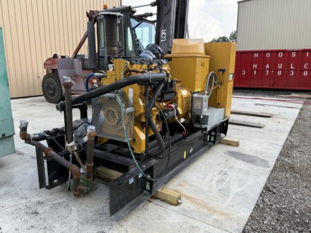 Caterpillar C9 diesel generator set on open skid frame with wiring and piping connections.
