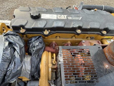 Caterpillar C9 ACERT diesel engine close-up with protective covering and components visible.