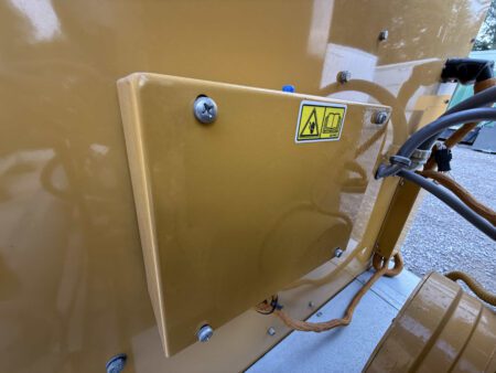 Close-up of Caterpillar generator electrical junction box with safety warning label.