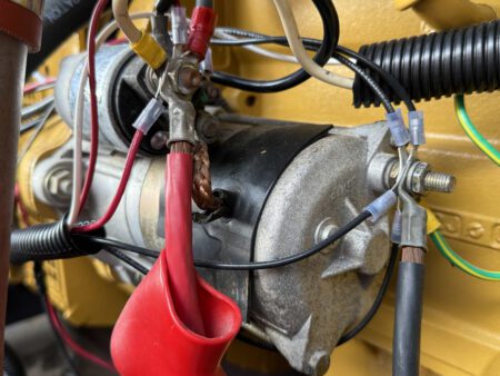Starter motor with electrical wiring on CAT C4.4 generator.
